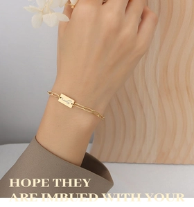Dettaglio del bracciale in titanio placcato oro 18K con ciondolo Lucky sul polso
