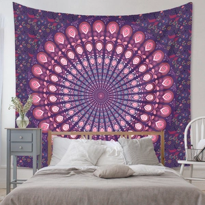Détail de tapisserie mandala bohème violette suspendue au-dessus d'un lit de chambre à coucher