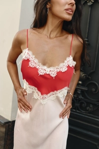 Detail of red and champagne satin slip dress with white lace trim and delicate straps
