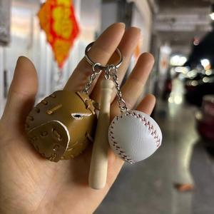 Close-up of mini baseball keyring set with brown glove, white ball and wooden bat