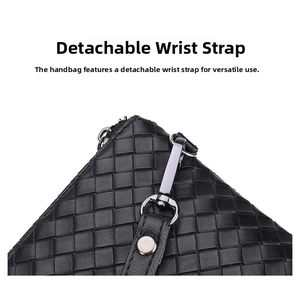 Detail of woven leather clutch showing detachable wrist strap and polished silver hook