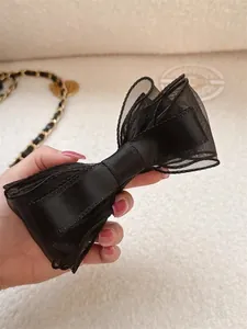 Close-up of elegant double-layered black mesh bow hair clip with satin ribbon texture