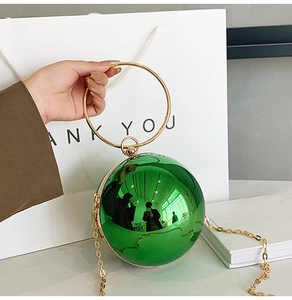 Dettaglio della borsa da sera sferica verde metallizzato con manico ad anello dorato