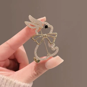 Detail shot of cute gold rabbit brooch featuring sparkling rhinestones and a bow accent