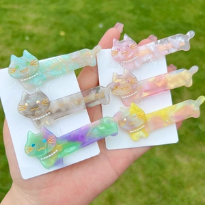 Detail of colorful acetate cat hair clips with pearl collars and sparkling rhinestone eyes