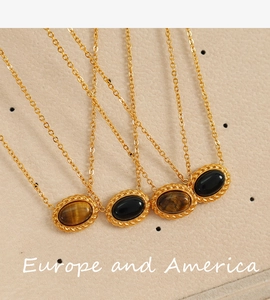 Detail of vintage oval tiger eye stone pendants on golden chains over beige leather