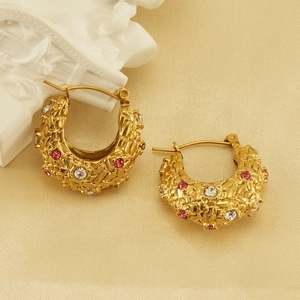 Detail of 18K gold plated hoop earrings with woven texture and pink zircon inlay