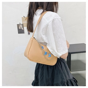 Detail of khaki shoulder bag featuring silver chain strap with blue butterfly charms