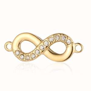 Close-up of gold infinity charm with inset crystals and dual loops on white background