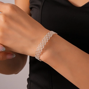 Close-up of intricate lace-style hollow floral silver bangle on a model's wrist