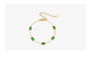 Détail macro du bracelet en or 18K avec zircons verts coupe émeraude et poinçon gravé K18