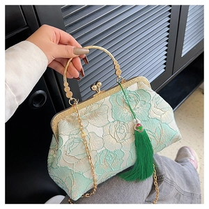 Detail of mint green lace embroidery shell bag with metal handle and silk tassel