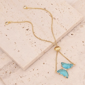 Detail of 18K gold butterfly bracelet with blue gemstones and adjustable pull chain