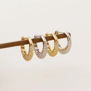 Macro detail of gold and silver hoop earrings with shimmering pave-set cubic zirconia