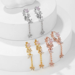 Detailed close-up of butterfly floral drop earrings in silver gold and rose gold finishes