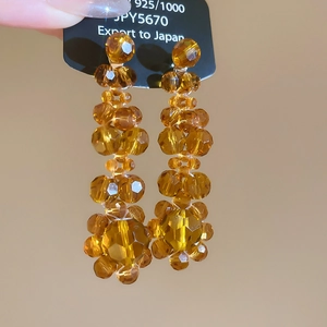 Detailed close-up of amber faceted crystal beaded tassel earrings with 925 silver needles
