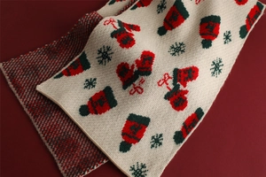 Close-up of double-sided knit scarf with festive glove patterns and red plaid texture