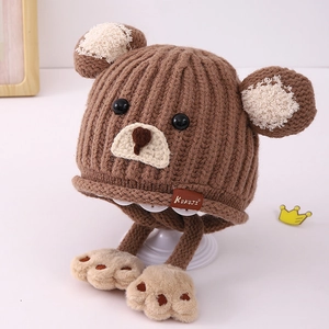 Detail der weichen braunen Strickmütze für Kinder mit Bärenohren und Leder-Markenetikett