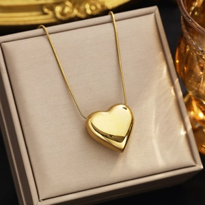 Gros plan détaillé du pendentif coeur doré sur un coffret cadeau à bijoux en cuir
