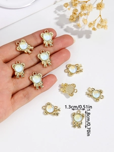 Detail shot of golden alloy bear bow charm with white pearl bead for DIY jewelry making