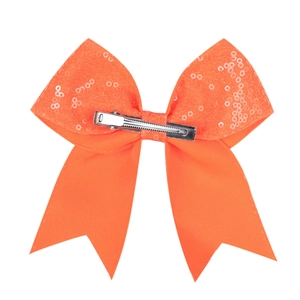 Back view of orange sequin bow hair clip showing silver metal duckbill clip detail