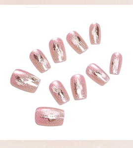 Détail de faux ongles œil de chat rose avec feuilles d'argent et paillettes
