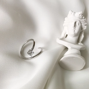 Minimalist S925 sterling silver spiral ring with square zircon on white silk background
