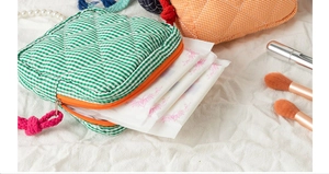 Detail of quilted cotton pouches in green and orange checkers with soft padding and zip