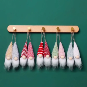 Set of 10 festive knit Christmas gnome plush ornaments hanging on a wooden hook rack