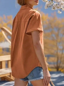Détail d'un chemisier orange à manches courtes avec col à revers et coupe décontractée