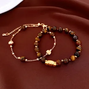 Bracelets en perles d'oeil de tigre avec détails dorés sur fond de velours brun