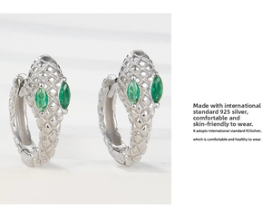 Macro view of S925 silver snake earrings featuring green zircon eyes and scale texture