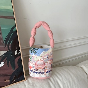 Detail of cute cartoon bucket bag showing the soft padded handles and magnetic snap closure