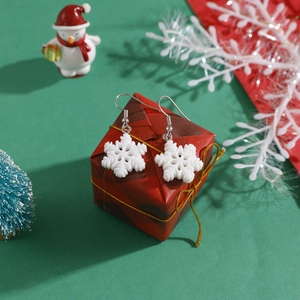 Detailed view of white snowflake resin hook earrings placed on a festive gift box
