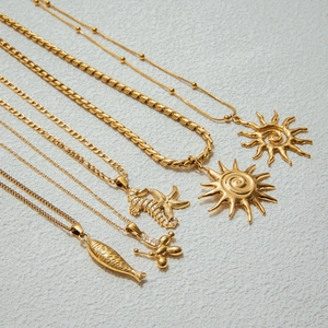 Detailed close-up of gold stainless steel necklaces with sun and animal pendants