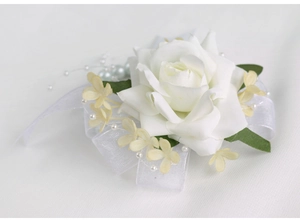 Détail de corsage de mariage avec rose en soie blanche, fleurs jaunes et ruban perlé