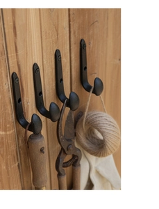 Industrial black cast iron J-hook mounted on wood showing vintage rustic style and hardware detail