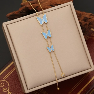 Detailed shot of golden snake chain with light blue butterfly and crystal charms