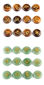 Tiger eye and aventurine rune stones with golden engraved zodiac symbols on white background