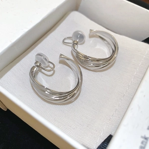 Detail of twisted multi-layer silver metal hoop earrings with clear silicone pads