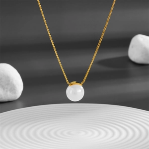 Minimalist titanium steel gold necklace with white pearl pendant on elegant prop display