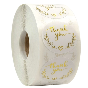 Close-up of pink and gold foil heart Thank You stickers roll for gift packaging labels