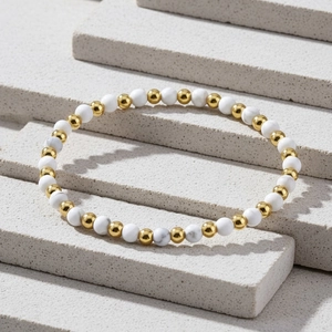 Detail of 4mm amazonite beads mixed with gold plated copper beads on textured stone