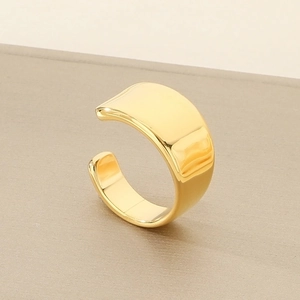 Macro shot of polished gold-plated stainless steel wide band ring with glossy finish