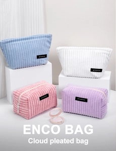 Detail of multi-color velvet makeup bags with vertical stripe texture and zip closure