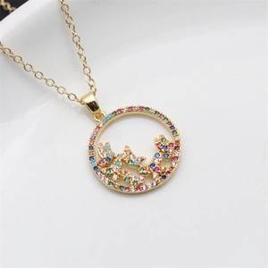 Detail of gold butterfly pendant featuring colorful cubic zirconia on a white ceramic plate