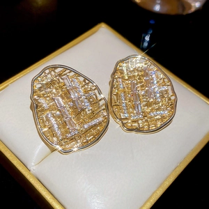 Gros plan de boucles d'oreilles en maille dorée avec zircon dans un écrin à bijoux