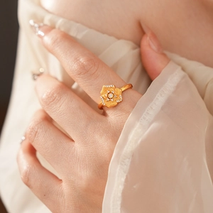 Macro detail of golden vintage floral ring with matte texture and sparkling zircons