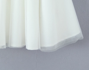 Nahaufnahme des mehrlagigen weißen Tüllsaums an einem süßen Kleid im Prinzessinnen-Stil