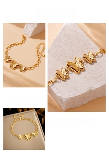 Close-up of gold butterfly charms on an adjustable O-chain link bracelet with lobster clasp